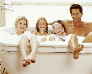 Family relaxing in bath (children 6 10), portrait